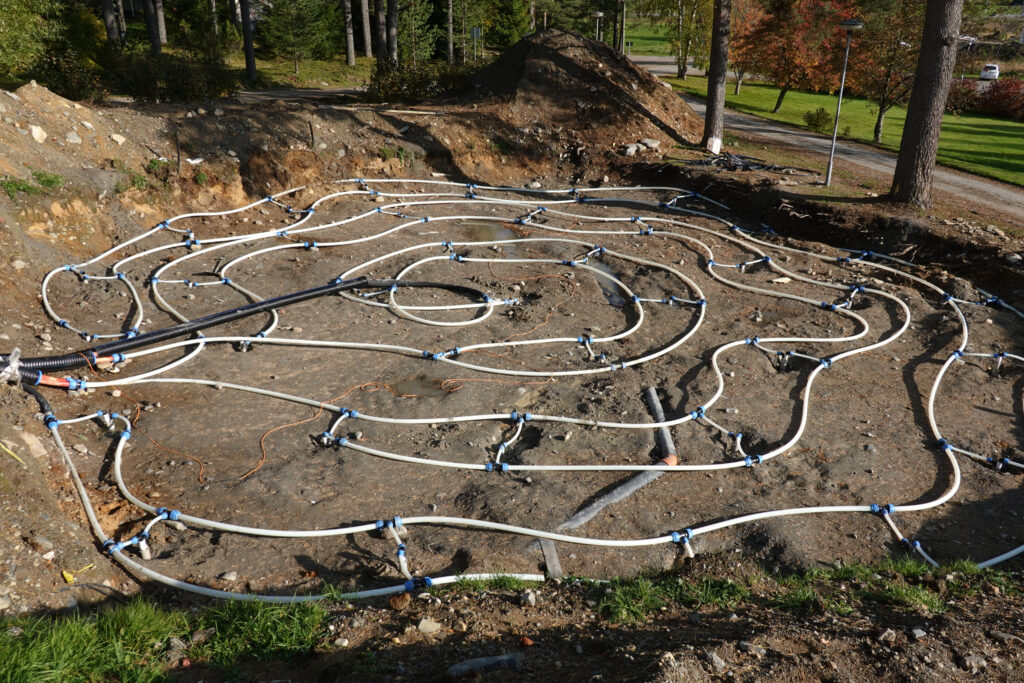 Lämmön kausivaraston asennusvaihe. Maahan kaivettu spiraalinmuotoinen putkisto, joka toimii lämpöakkuna varastoiden energiaa maaperään.